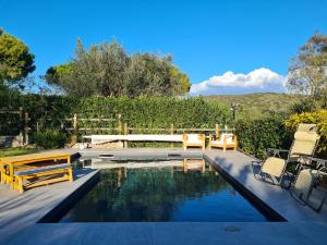 a swimming pool with two chairs and a table at Portion of a villa with a private pool in Ansedónia