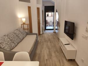 a living room with a couch and a flat screen tv at Apartamentos Casa Yaya al lado de Port Aventura in Vila-seca