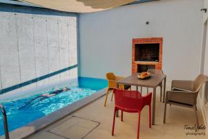 a room with a swimming pool with a table and chairs at Villa Marisari in Otok Lastovo