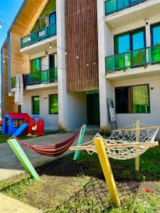 a playground with a hammock in front of a building at Snow Forest ԲԱԿՈՒՐԻԱՆԻ-ბაკურიანი-BAKURIANI in Bakuriani +33 photos