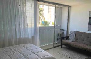 a bedroom with a bed and a large window at The Sandy Pearl Apartment in Luquillo +5 photos
