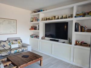 a living room with a couch and a flat screen tv at Portion of a villa with a private pool in Ansedónia