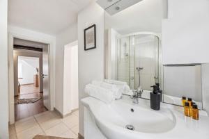 a white bathroom with a sink and a mirror at Altstadtidyll am See 1 - 6 Personen I Ruhig - Balkon - Parkplatz - nahe Bahnhof und Autobahn in Weesen +49 photos