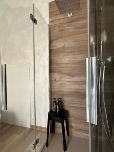 een badkamer met een glazen douche met een zwarte tafel bij La casa di Hermes in Imola +65 foto's
