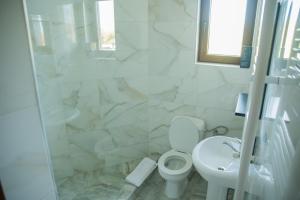 a white bathroom with a toilet and a sink at Craii Neamtului in Almaş +14 photos