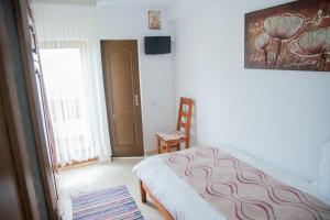 a bedroom with a bed and a chair in it at Craii Neamtului in Almaş