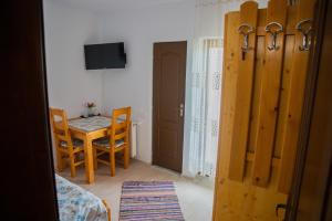 a room with a table and a chair and a door at Craii Neamtului in Almaş