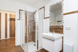 a white bathroom with a sink and a shower at Apartment im Stadtzentrum von Riesa in Riesa