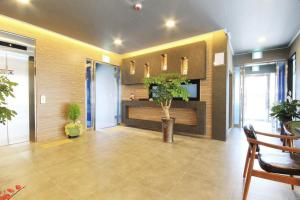 全州市にあるJeonju Raon Hotelの受付デスクと植物のあるオフィスロビー