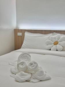 ปิกรพลอย บูทีค โฮเทล PIKORNPLOY Boutique Hotel : لفتين من المناشف على سرير أبيض