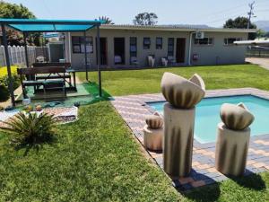 een achtertuin met een zwembad en een huis bij Twilight Inn in Vryheid