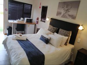 een slaapkamer met een groot wit bed met kussens bij Twilight Inn in Vryheid +16 foto's