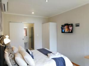een slaapkamer met een bed en een tv aan de muur bij Twilight Inn in Vryheid