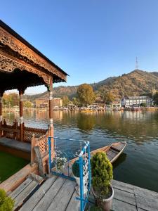 een houten steiger met een boot op het water bij Houseboat Trambak in Srinagar