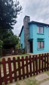a blue house with a fence in front of it at Hermosa casa con piscina en Bella Vista Piriápolis a 2 c de la playa in Bella Vista