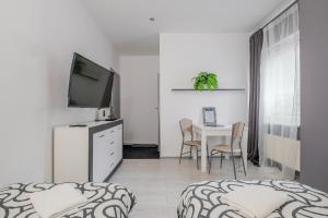a white room with a table with chairs and a television at Hostel Gdynia - Pokoje 2-osobowe na wyłączność in Gdynia +104 photos