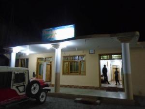 two people standing outside of a gas station at night at Star Rise Hotel in Naran