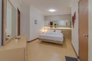 a bedroom with a white bed and a hallway at 2BR Apartment Majesty W Pool in Bandung