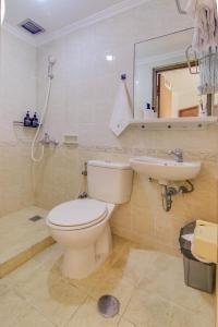 a bathroom with a toilet and a sink and a mirror at 2BR Apartment Majesty W Pool in Bandung