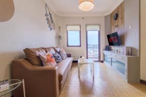 a living room with a couch and a table at 2BR Apartment Majesty W Pool in Bandung