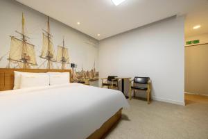 全州市にあるJeonju Raon Hotelの大きなベッドと船の絵が飾られた壁のある寝室 +35枚の写真