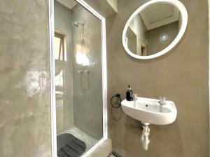 a bathroom with a sink and a shower with a mirror at OR Tambo Stay Unit 1 in Boksburg