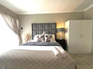 a bedroom with a large bed with two dogs on it at OR Tambo Stay Unit 1 in Boksburg