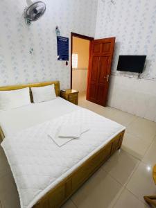 a bedroom with a large white bed with a sign on it at Phát Đại Nam Motel in Xóm Hóc