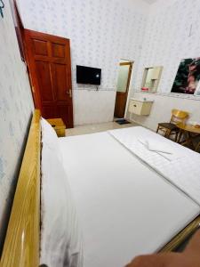 a large bed in a room with a tv at Phát Đại Nam Motel in Xóm Hóc