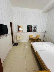 a bedroom with a bed and two chairs and a tv at Phát Đại Nam Motel in Xóm Hóc