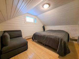 a bedroom with a bed and a couch in a attic at Lusseeri in Kalajoki