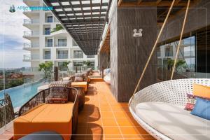 a balcony with swings and a pool on a building at Mandala Wins Hotel Phú Yên in Phước Hậu