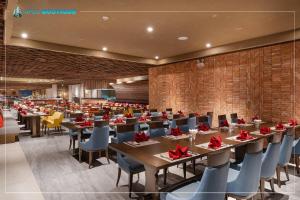 a dining room with tables and chairs with red bows at Mandala Wins Hotel Phú Yên in Phước Hậu