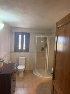a bathroom with a toilet and a glass shower at Razzett ta' Sinna in Għargħur
