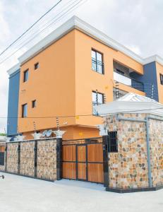a orange building with a fence and a garage at Appartements meublés mpita in Pointe-Noire +79 photos