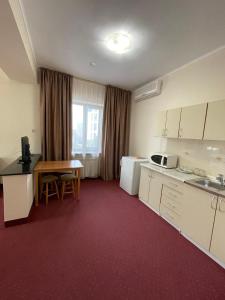 a room with a kitchen with a table and a desk at Alma in Almaty