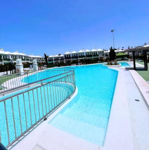 a swimming pool with blue water in a resort at Paradise Dreams in Maspalomas