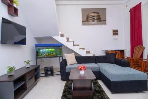 un salon avec un canapé bleu et une télévision dans l'établissement Aru Villa Galle, à Galle 4 autres photos