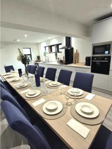 a long dining table with chairs and a kitchen at The Waltzing Weasel in Birch Vale
