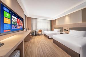 een hotelkamer met twee bedden en een flatscreen-tv bij Jingyue Yaduo Hotel in Yiwu