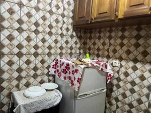 una pequeña cocina con una mesa encima de un refrigerador en King's home, en Yaoundé 7 fotos más