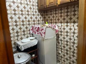 una pequeña cocina con nevera blanca y fregadero en King's home, en Yaoundé