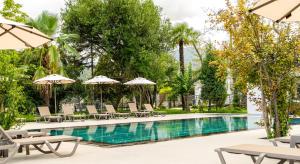 a swimming pool with lounge chairs and umbrellas at Wellwood Otel in Sapanca +18 photos
