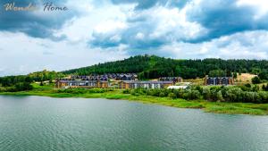 une vue aérienne d'un complexe hôtelier au bord d'une rivière dans l'établissement Wonder Hill - apartamenty z klimatyzacją, balkonami lub trasami, à Sosnówka