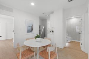 a white dining room with a white table and chairs at Sea View Play in New Smyrna Beach +81 photos