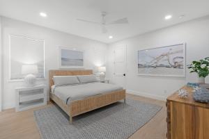 a bedroom with a bed and a dresser and a table at Sea View Play in New Smyrna Beach
