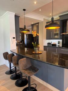 eine Küche mit einer großen Insel mit Barhockern in der Unterkunft Contemporary Constantia Villa of Elegance in Doordrift