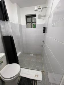 La salle de bains est pourvue de toilettes, d'une douche et d'une fenêtre. dans l'établissement Anakwa Villas, à Nairobi 8 autres photos