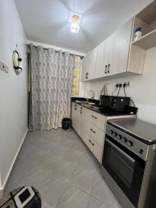 une petite cuisine avec une cuisinière et un évier dans l'établissement Anakwa Villas, à Nairobi