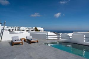 a patio with two chairs and a swimming pool at Oikos Santorini Living Concept in Fira